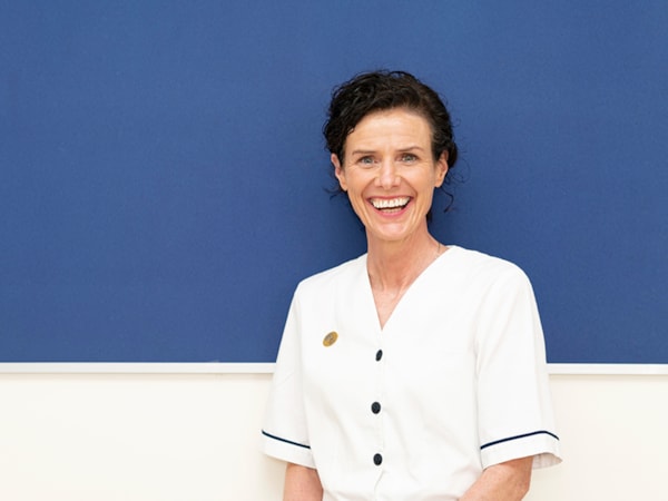 Member in uniform against a blue wall